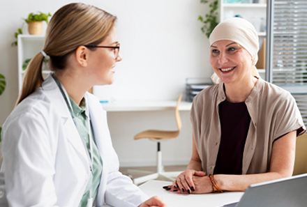 An oncologist is consulting with a smiling female patient.